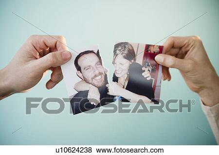 Close up of man's and woman's hands holding torn photograph of themselves, studio shot View Large Photo Image Stock Photo - Close up of man's and woman's hands holding torn photograph of themselves, studio shot. Fotosearch
