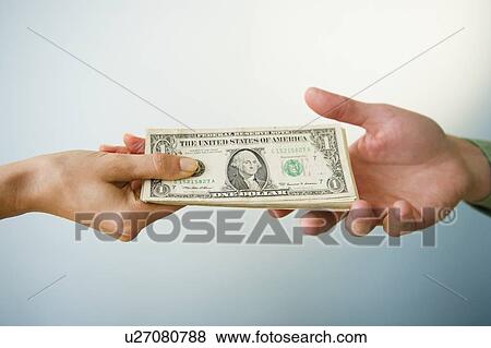Close up of man's and woman's hands holding banknotes, studio shot View Large Photo Image Stock Photo - Close up of man's and woman's hands holding banknotes, studio shot. Fotosearch