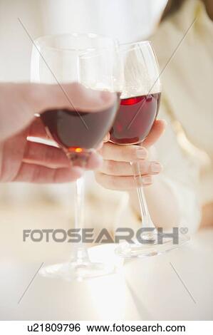 Close up of man's and woman's hands making toast with red wine View Large Photo Image Stock Photograph - Close up of man's and woman's hands making toast with red wine. Fotosearch