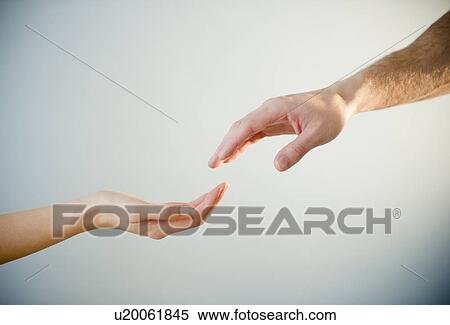 Stock Photography - Close up of man's and woman's hands, studio shot. Fotosearch