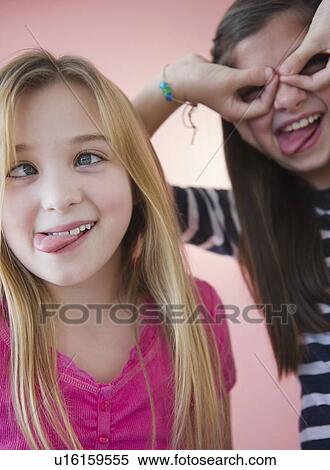 Stock Photography - Close up of two girls making faces. Fotosearch