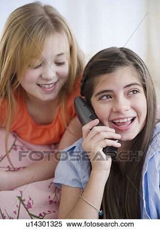 Stock Photography - Close up of two girls talking on phone. Fotosearch
