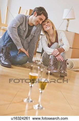 Close up of wine glasses on floor with couple behind View Large Photo Image Stock Image - Close up of wine glasses on floor with couple behind. Fotosearch