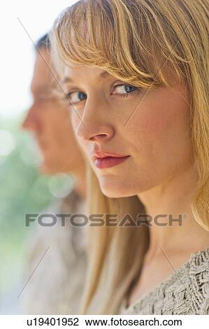 Close up woman's face with man in background View Large Photo Image Stock Image - Close up woman's face with man in background. Fotosearch