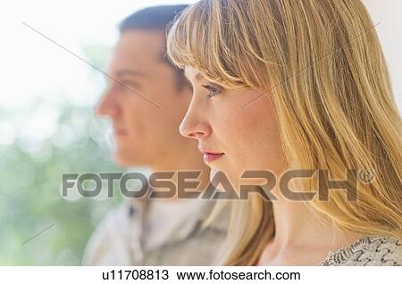 Stock Image - Close up woman's profile with man in background. Fotosearch