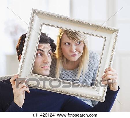 Couple holding picture frame and making faces View Large Photo Image Picture - Couple holding picture frame and making faces. Fotosearch