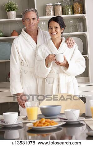 Couple in bathrobes with coffee cups View Large Photo Image Stock Photo - Couple in bathrobes with coffee cups. Fotosearch