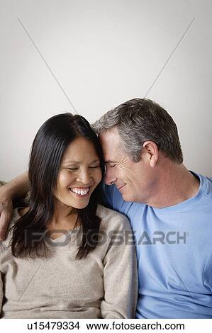 Couple in close embrace sitting on sofa View Large Photo Image Picture - Couple in close embrace sitting on sofa. Fotosearch