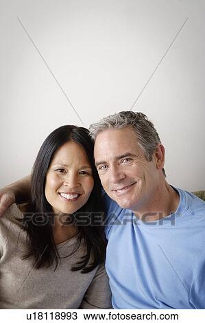Couple in close embrace sitting on sofa View Large Photo Image Stock Image - Couple in close embrace sitting on sofa. Fotosearch