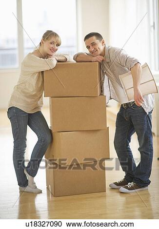 Couple leaning on cardboard boxes during relocation View Large Photo Image Stock Image - Couple leaning on cardboard boxes during relocation. Fotosearch
