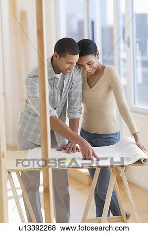 Couple looking at house blueprints View Large Photo Image Stock Photo - Couple looking at house blueprints. Fotosearch