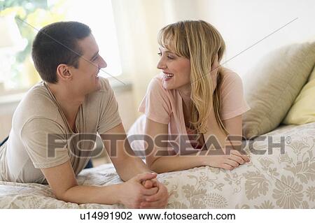 Stock Image - Couple lying on bed . Fotosearch