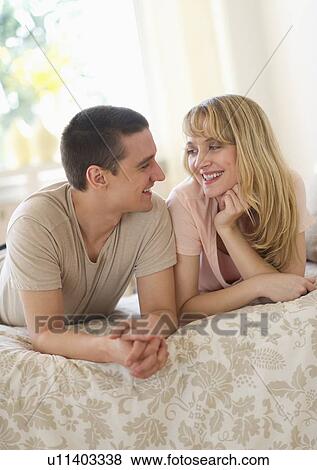 Couple lying on bed View Large Photo Image Stock Photo - Couple lying on bed . Fotosearch