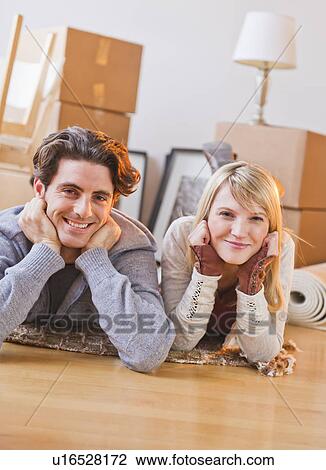 Stock Image - Couple lying on floor. Fotosearch
