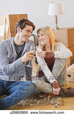 Stock Photography - Couple making toast sitting on floor. Fotosearch