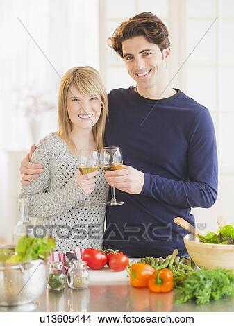 Picture - Couple preparing food in kitchen and making toast. Fotosearch
