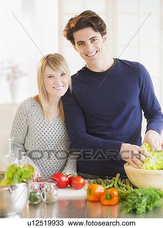 Couple preparing food in kitchen View Large Photo Image Stock Image - Couple preparing food in kitchen. Fotosearch
