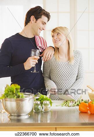 Stock Image - Couple preparing food in kitchen. Fotosearch