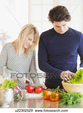 Couple preparing food in kitchen View Large Photo Image Stock Photo - Couple preparing food in kitchen. Fotosearch