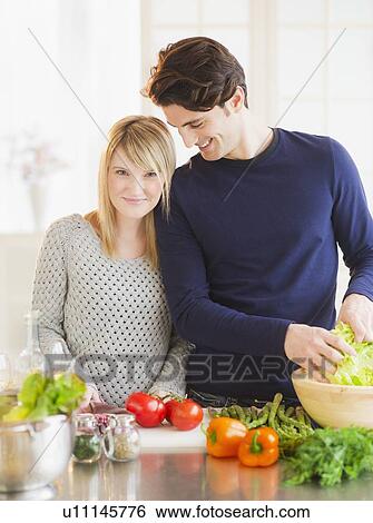 Couple preparing food in kitchen View Large Photo Image Stock Photograph - Couple preparing food in kitchen. Fotosearch
