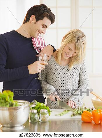 Stock Photography - Couple preparing food in kitchen. Fotosearch