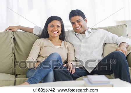 Couple sitting on sofa View Large Photo Image Stock Image - Couple sitting on sofa. Fotosearch