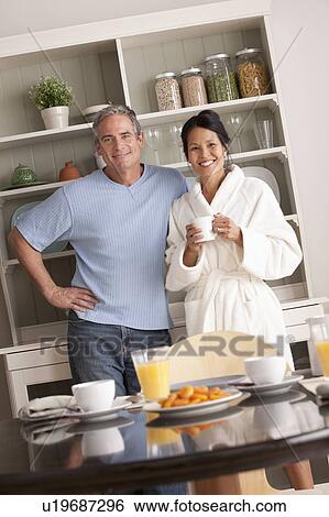 Couple standing over breakfast table View Large Photo Image Stock Photograph - Couple standing over breakfast table. Fotosearch
