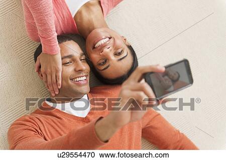 Stock Image - Couple taking photo with smartphone. Fotosearch
