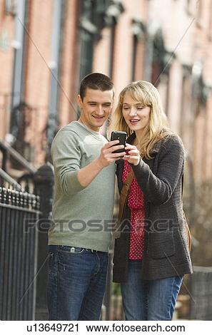 Couple using smart phone on street View Large Photo Image Stock Image - Couple using smart phone on street. Fotosearch