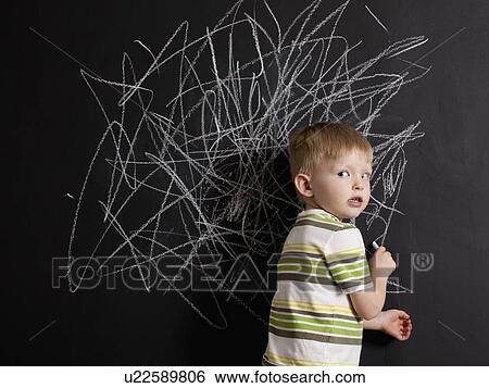Cute toddler boy (2-3) standing against blackboard with daub written in chalk View Large Photo Image Stock Photograph - Cute toddler boy (2-3) standing against blackboard with daub written in chalk. Fotosearch