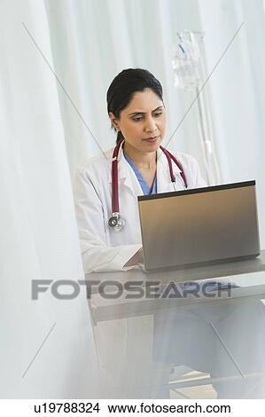 Doctor working on laptop View Large Photo Image Picture - Doctor working on laptop. Fotosearch