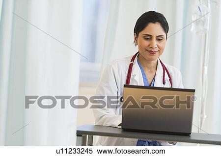 Doctor working on laptop View Large Photo Image Stock Photography - Doctor working on laptop. Fotosearch