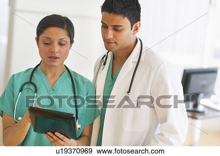 Stock Photo - Doctors using digital tablet. Fotosearch