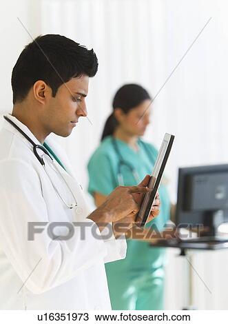 Doctors working on digital tablet and computer View Large Photo Image Stock Image - Doctors working on digital tablet and computer. Fotosearch