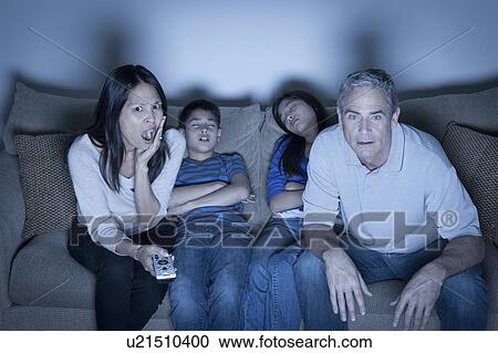Family sitting on sofa and watching television View Large Photo Image Stock Image - Family sitting on sofa and watching television. Fotosearch