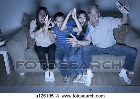 Family sitting on sofa and watching television View Large Photo Image Stock Photo - Family sitting on sofa and watching television. Fotosearch