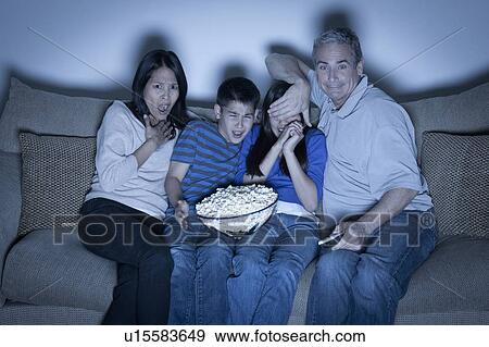 Family sitting on sofa and watching television View Large Photo Image Stock Photo - Family sitting on sofa and watching television. Fotosearch
