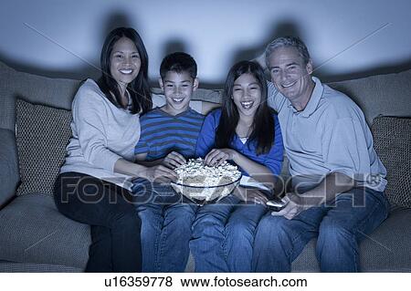 Family sitting on sofa and watching television View Large Photo Image Stock Photo - Family sitting on sofa and watching television. Fotosearch