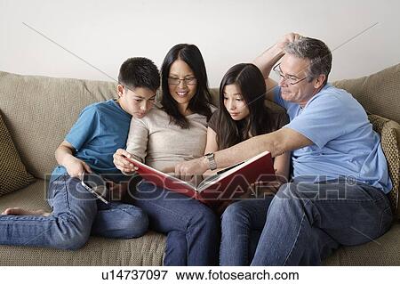 Family watching photo album together View Large Photo Image Stock Photo - Family watching photo album together. Fotosearch