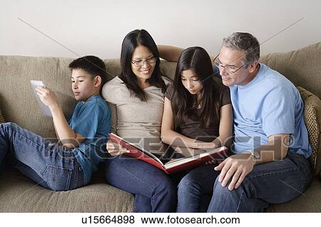 Family watching photo album together View Large Photo Image Stock Photo - Family watching photo album together. Fotosearch