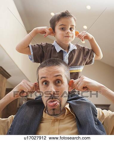 Father and son (6-7) pulling funny faces View Large Photo Image Stock Image - Father and son (6-7) pulling funny faces. Fotosearch