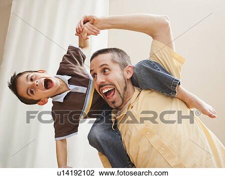 Father carrying his son (6-7) on shoulders View Large Photo Image Stock Image - Father carrying his son (6-7) on shoulders . Fotosearch