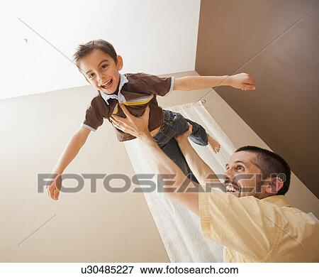 Father holding aloft his son (6-7) View Large Photo Image Stock Photo - Father holding aloft his son (6-7). Fotosearch