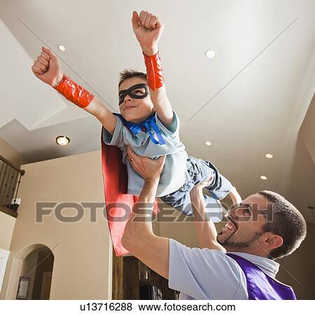 Father holding aloft his son (8-9) dressed up in fancy dress costume View Large Photo Image Stock Photo - Father holding aloft his son (8-9) dressed up in fancy dress costume. Fotosearch