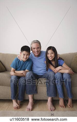 Father with children embracing on sofa View Large Photo Image Stock Photo - Father with children embracing on sofa. Fotosearch
