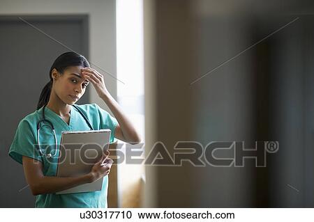 Female nurse with head in hands View Large Photo Image Stock Image - Female nurse with head in hands. Fotosearch