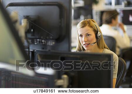 Stock Image - Female trader at trading desk. Fotosearch