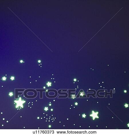 Stock Image - Fluorescent stars on blue background, studio shot. Fotosearch