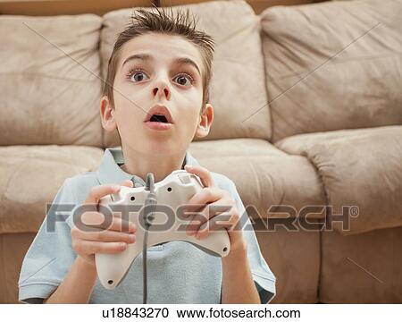 Front view of boy (8-9) playing Video Games View Large Photo Image Stock Image - Front view of boy (8-9) playing Video Games. Fotosearch