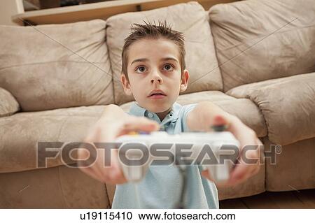Front view of boy (8-9) playing Video Games View Large Photo Image Stock Image - Front view of boy (8-9) playing Video Games. Fotosearch